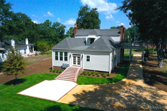 back of property featuring a lawn, a shingled roof, french doors, and a chimney