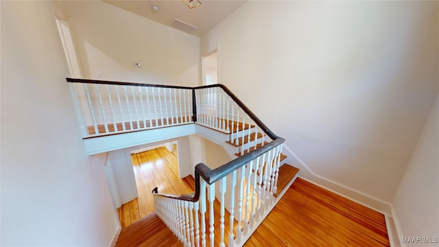stairs with wood finished floors and baseboards