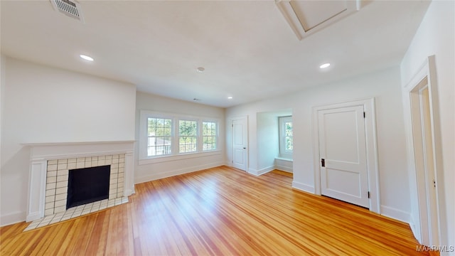 unfurnished living room with recessed lighting, a fireplace, visible vents, light wood-style flooring, and baseboards