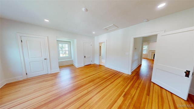 empty room with baseboards, light wood-style flooring, and a healthy amount of sunlight