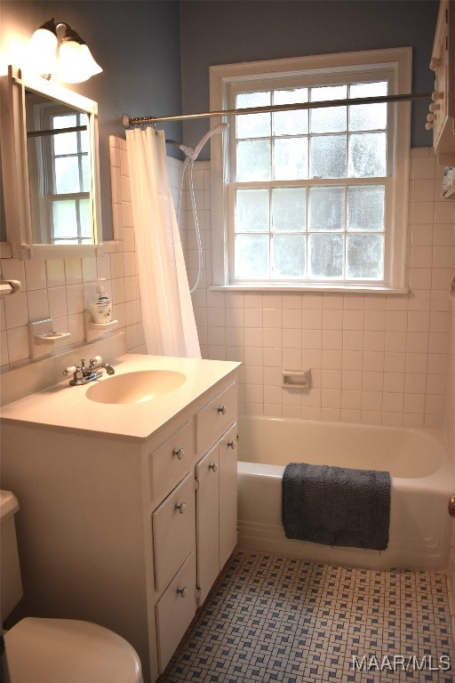 full bathroom with tile walls, toilet, and vanity