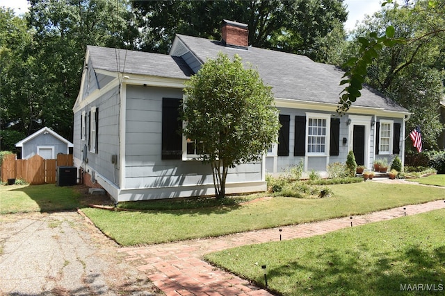 view of front of home featuring central air condition unit and a front yard