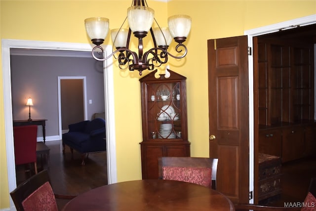 dining space featuring an inviting chandelier and dark hardwood / wood-style flooring