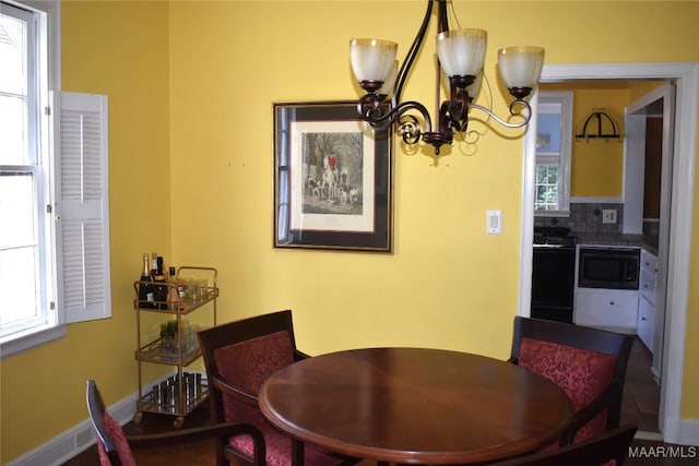 dining space featuring tile patterned flooring and a notable chandelier