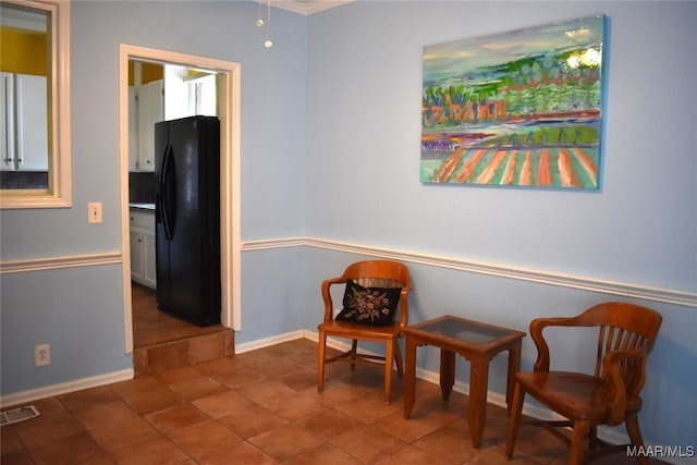 living area with crown molding and tile patterned floors