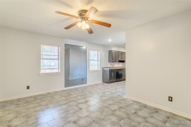 unfurnished living room featuring ceiling fan and a textured ceiling