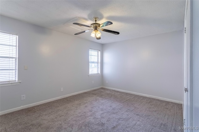 carpeted spare room with ceiling fan and a textured ceiling