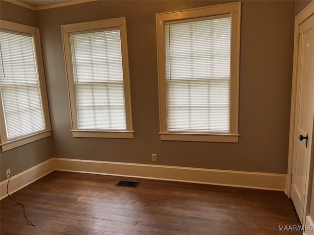 spare room featuring dark hardwood / wood-style flooring and ornamental molding