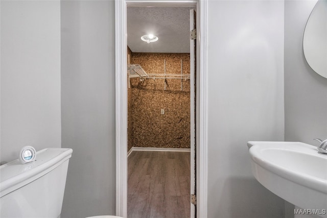 bathroom with toilet, sink, and hardwood / wood-style flooring