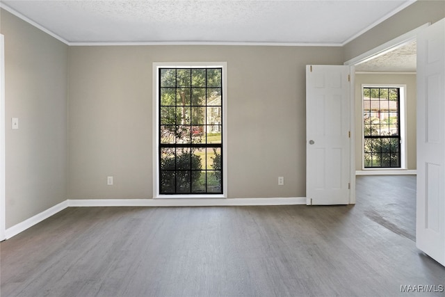 spare room featuring ornamental molding, a textured ceiling, and hardwood / wood-style flooring