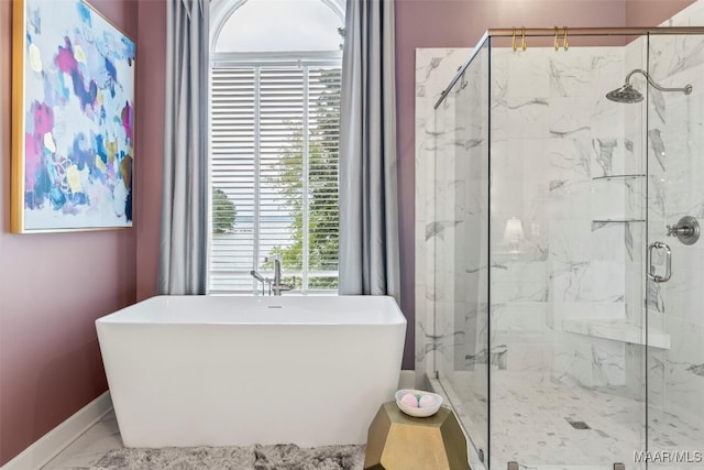 bathroom with a freestanding tub, baseboards, marble finish floor, and a marble finish shower