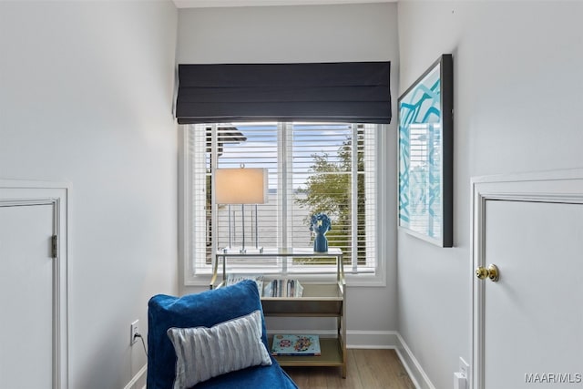 living area featuring a healthy amount of sunlight, baseboards, and wood finished floors