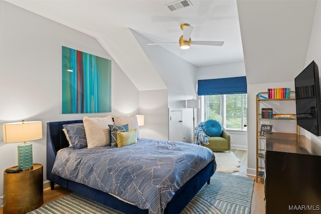 bedroom featuring baseboards, visible vents, ceiling fan, wood finished floors, and vaulted ceiling