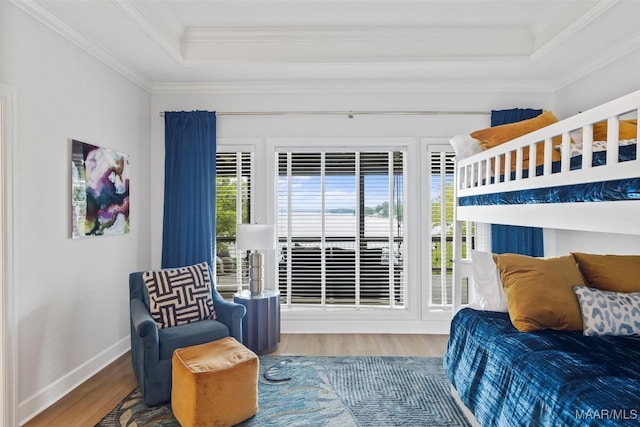 bedroom featuring multiple windows, a tray ceiling, and wood finished floors