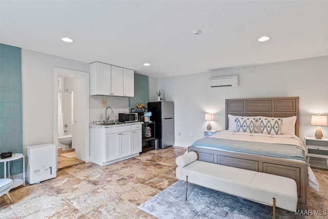 bedroom featuring a wall unit AC, recessed lighting, and freestanding refrigerator