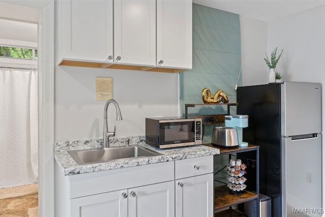 kitchen with stainless steel appliances, white cabinets, and a sink