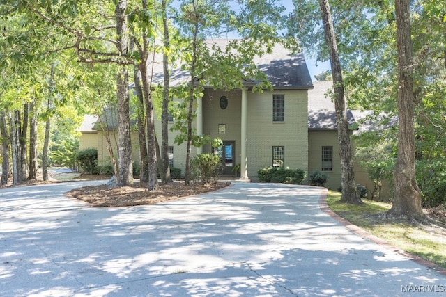 greek revival house with driveway and brick siding