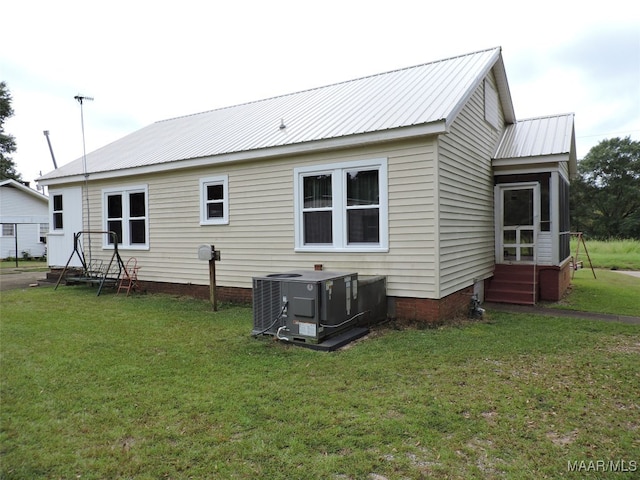 rear view of house featuring a yard and cooling unit