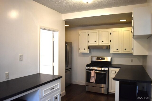 kitchen with appliances with stainless steel finishes, a textured ceiling, dark wood-type flooring, and white cabinets