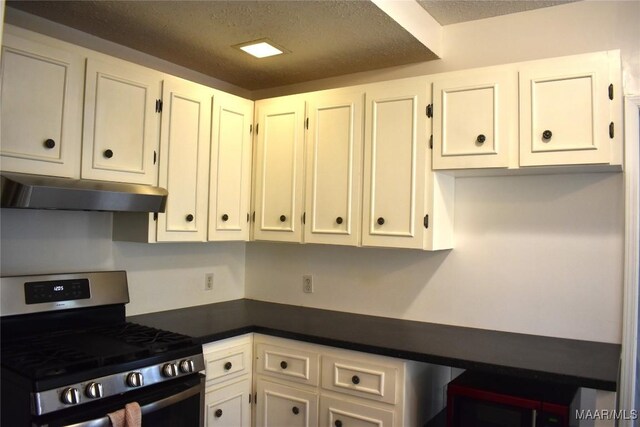 kitchen featuring a textured ceiling, stainless steel range with gas cooktop, and white cabinets