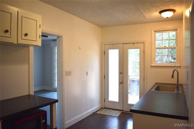 interior space featuring french doors, a textured ceiling, sink, and dark wood-type flooring