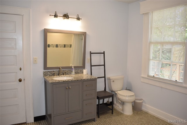 bathroom featuring tile patterned flooring, vanity, and toilet