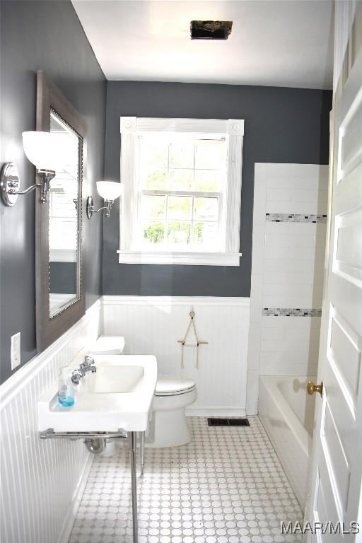 full bathroom with toilet, sink, tile patterned floors, and tiled shower / bath