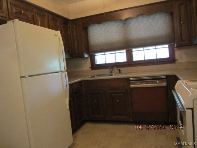 kitchen featuring white fridge, dark brown cabinets, dishwasher, sink, and range