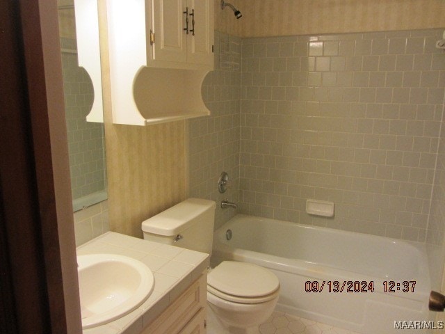 full bathroom with vanity, toilet, and tiled shower / bath