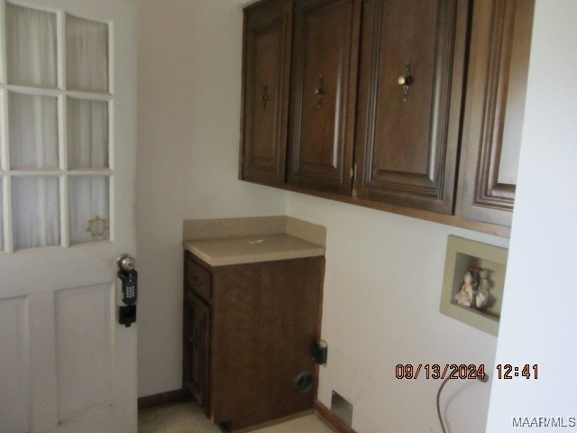 clothes washing area with washer hookup and cabinets