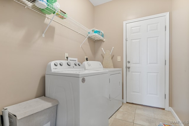 washroom featuring washing machine and dryer and light tile patterned floors