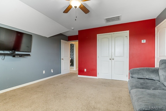 carpeted living room with ceiling fan