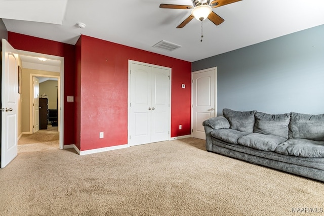 carpeted living room with ceiling fan