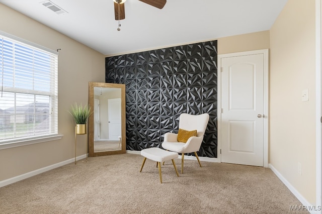 sitting room featuring ceiling fan, a wealth of natural light, and carpet