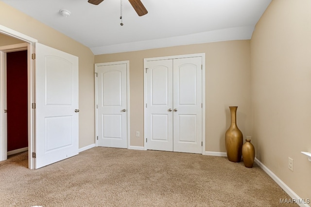 unfurnished bedroom featuring ceiling fan, carpet, and vaulted ceiling