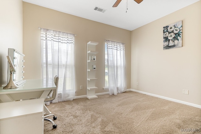 carpeted office space with ceiling fan