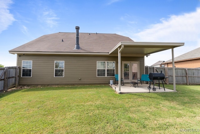 back of property with a patio area and a yard