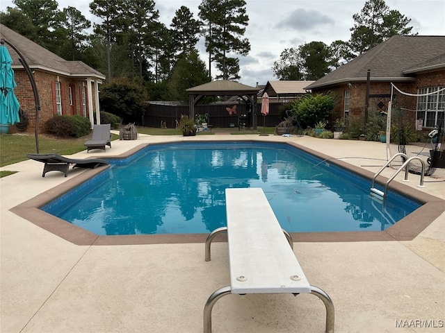 view of swimming pool featuring a patio, a diving board, and a gazebo