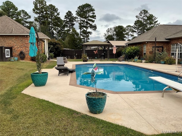 view of pool with a patio, a yard, a gazebo, and a diving board