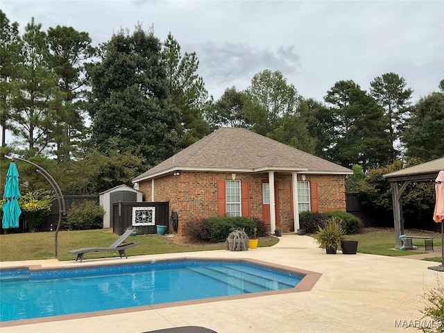 view of swimming pool with a storage unit, a patio, a gazebo, and a lawn