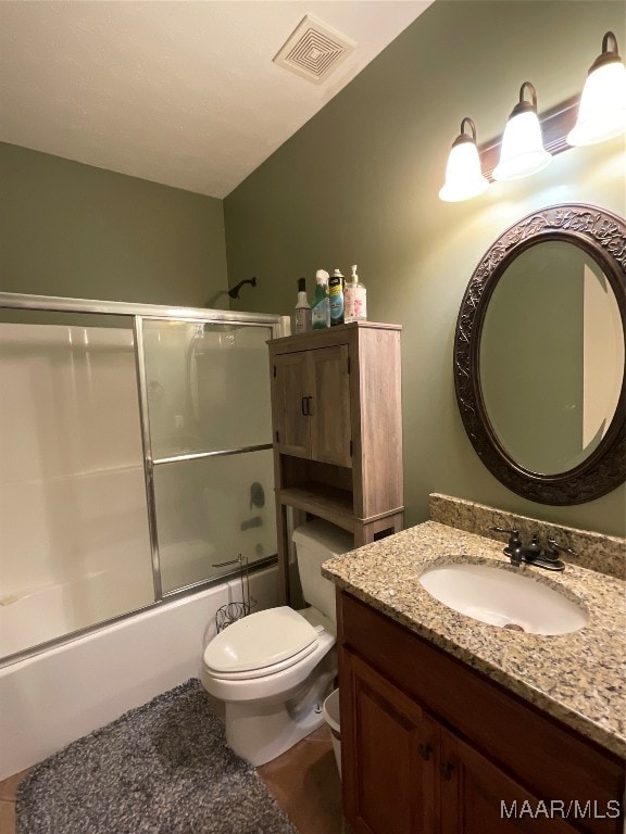 full bathroom featuring combined bath / shower with glass door, vanity, and toilet