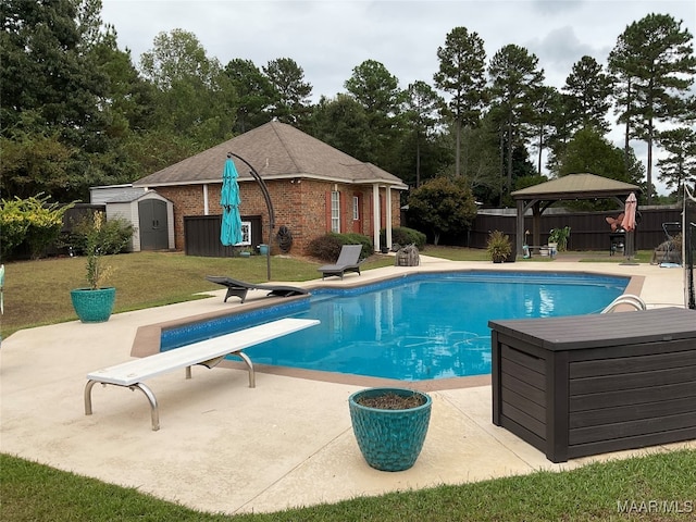 view of pool with a diving board, a shed, a patio area, a yard, and a gazebo