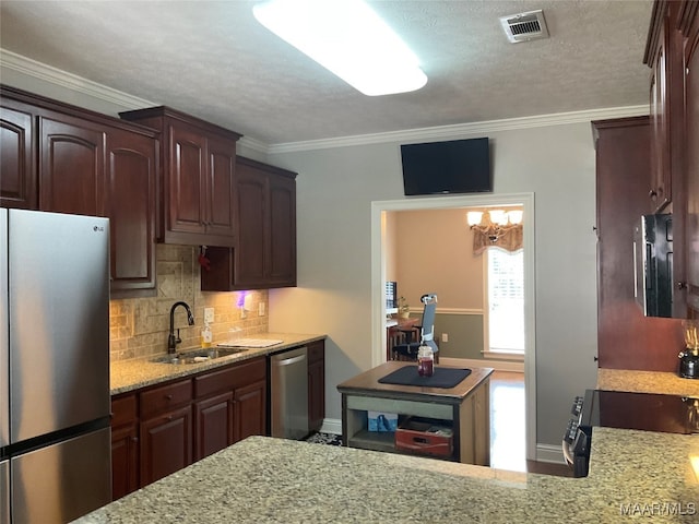 kitchen with a textured ceiling, sink, decorative backsplash, appliances with stainless steel finishes, and crown molding