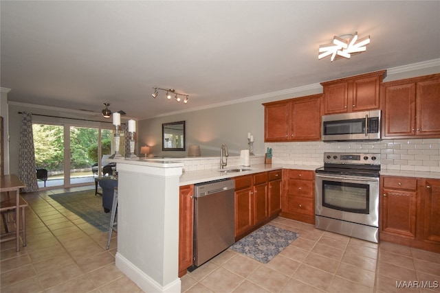 kitchen featuring crown molding, kitchen peninsula, stainless steel appliances, and sink