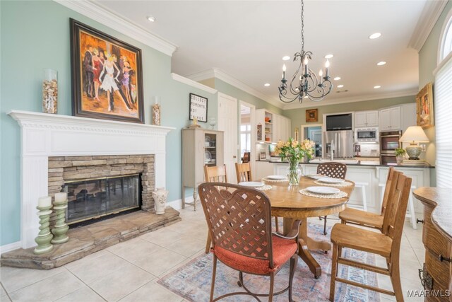 tiled dining room with a wealth of natural light, an inviting chandelier, crown molding, and a stone fireplace