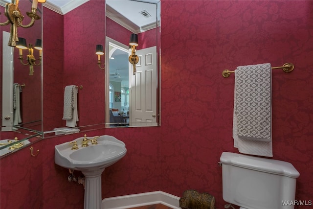 bathroom with crown molding and toilet