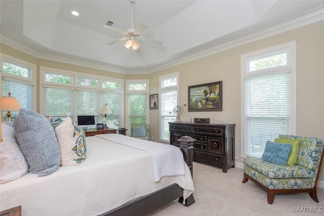 bedroom with multiple windows, ceiling fan, a tray ceiling, and ornamental molding