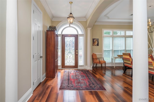 foyer with dark hardwood / wood-style floors, crown molding, and ornate columns