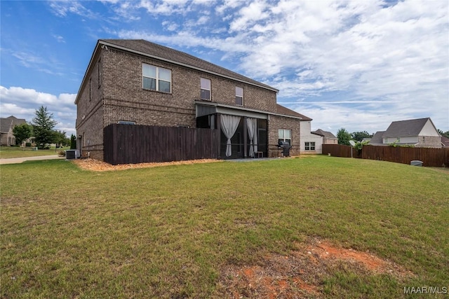 rear view of house featuring a yard and central AC unit