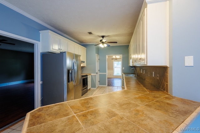 kitchen featuring white cabinets, light tile patterned floors, stainless steel appliances, and ceiling fan